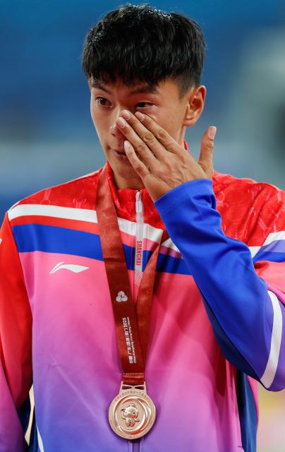(251116) -- GUANGZHOU, Nov. 16, 2025 (Xinhua) -- Bronze medalist Fei Xiang of Shanghai wipes tears during the awarding ceremony of the men's decathlon of athletics at China's 15th National Games in Guangzhou, south China's Guangdong Province, Nov. 16, 2025. (Xinhua/Huang Wei)