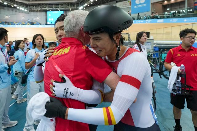 (251116) -- HONG KONG, Nov. 16, 2025 (Xinhua) -- Yang Yang (front R), Li Boan (front L) and their coach Gary John Sutton (front C) hug with each other after winning the men's Madison final of cycling track at China's 15th National Games in Hong Kong, south China, Nov. 16, 2025. (Xinhua/Wu Lu)