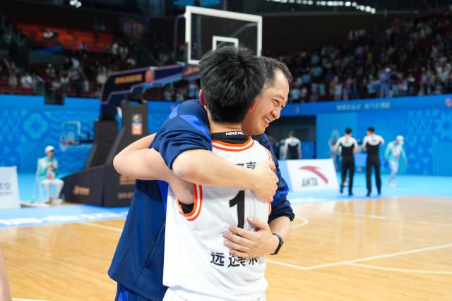(251116) -- SHENZHEN, Nov. 16, 2025 (Xinhua) -- Ran Kejia (front) of Sichuan hugs her coach Yangyi after winning the U22 women's final match of basketball between Sichuan and Zhejiang at China's 15th National Games in Shenzhen, south China's Guangdong Province, Nov. 16, 2025. (Xinhua/Chen Sihan)
