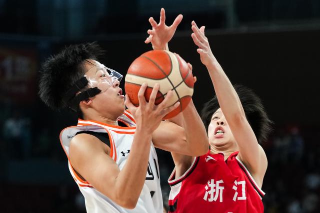 (251116) -- SHENZHEN, Nov. 16, 2025 (Xinhua) -- Ran Kejia (L) of Sichuan vies with Kong Xinjie of Zhejiang during the U22 women's final match of basketball between Sichuan and Zhejiang at China's 15th National Games in Shenzhen, south China's Guangdong Province, Nov. 16, 2025. (Xinhua/Chen Sihan)