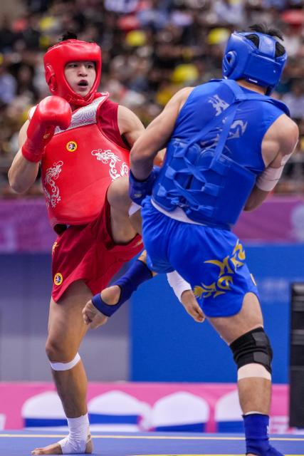 (251116) -- ZHANJIANG, Nov. 16, 2025 (Xinhua) -- Lin Hongwei (L) of Fujian competes against He Feng of Chongqing during the wushu sanda men's 75kg final at China's 15th National Games in Zhanjiang, south China's Guangdong Province, Nov. 16, 2025. (Xinhua/Li Bo)