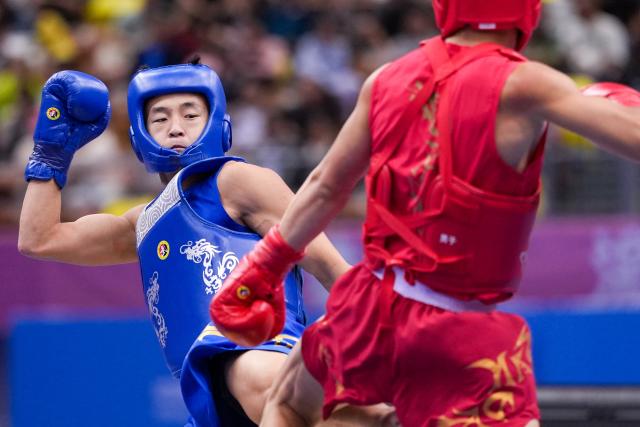 (251116) -- ZHANJIANG, Nov. 16, 2025 (Xinhua) -- Tang Sishuo (L) of Jiangsu competes with Huang Jiajun of Fujian during the wushu sanda men's 60kg final at China's 15th National Games in Zhanjiang, south China's Guangdong Province, Nov. 16, 2025. (Xinhua/Li Bo)