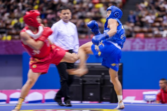 (251116) -- ZHANJIANG, Nov. 16, 2025 (Xinhua) -- Tang Sishuo (R) of Jiangsu competes with Huang Jiajun of Fujian during the wushu sanda men's 60kg final at China's 15th National Games in Zhanjiang, south China's Guangdong Province, Nov. 16, 2025. (Xinhua/Li Bo)
