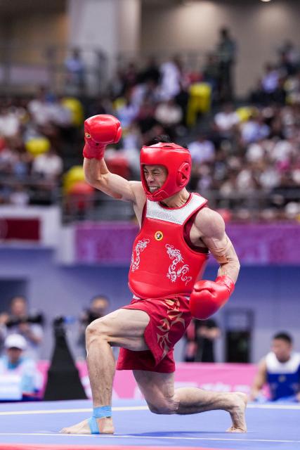 (251116) -- ZHANJIANG, Nov. 16, 2025 (Xinhua) -- Shen Guoshun of Henan celebrates scoring during the 56 kg event of wushu sanda men's team final at China's 15th National Games in Zhanjiang, south China's Guangdong Province, Nov. 16, 2025. (Xinhua/Li Bo)