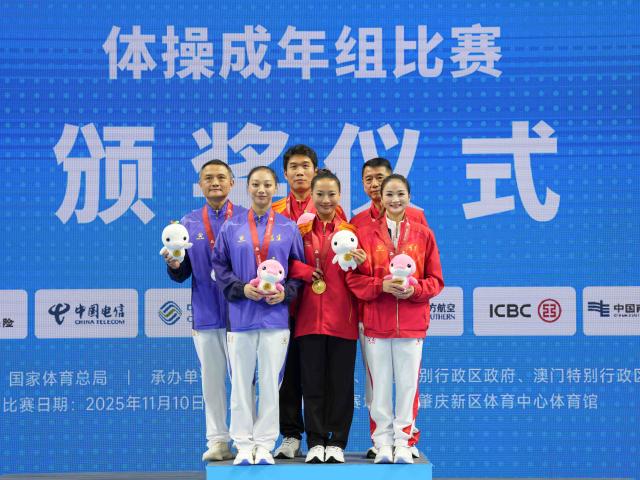 (251116) -- ZHAOQING, Nov. 16, 2025 (Xinhua) -- Gold medalist Deng Yalan of Jiangxi, silver medalist Yu Linmin of Fujian and bronze medalist Liu Jinru of Henan pose with their coaches during the awarding ceremony for the artistic gymnastics women's vault at China's 15th National Games in Zhaoqing, south China's Guangdong Province, Nov. 16, 2025. (Xinhua/Xu Bingjie)
