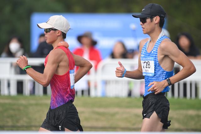 (251117) -- ZHUHAI, Nov. 17, 2025 (Xinhua) -- Shi Shengji (L) of Beijing competes during the marathon race walk relay mixed of Athletics at China's 15th National Games in Zhuhai, south China's Guangdong Province, Nov. 17, 2025. (Xinhua/Zhang Long)