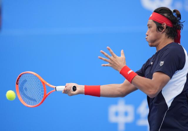 (251117) -- HENGQIN, Nov. 17, 2025 (Xinhua) -- Zhang Zhizhen hits a return during the men's singles third round match of tennis between Zhang Zhizhen of Shanghai and Fnu Nidunjianzan of Hebei at China's 15th National Games in Hengqin, south China's Guangdong Province, Nov. 17, 2025. (Xinhua/Yan Linyun)
