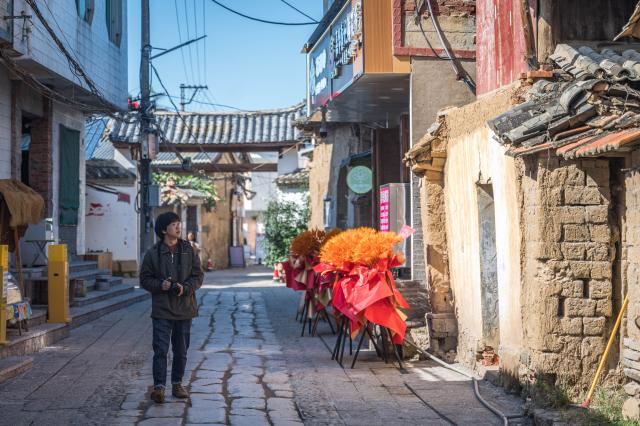 (251117) -- KUNMING, Nov. 17, 2025 (Xinhua) -- Zhang Hang collects images of Wamao with his camera at Haiyan Village in Kunming, southwest China's Yunnan Province, Nov. 12, 2025. Zhang Hang, 32, is an inheritor of the Kunming Wamao-making technique and the founder of the Heart Chamber Wamao Museum.
   Wamao, a cat-shaped pottery artifact originating in Yunnan, combines practical design with folk beliefs. Traditionally mounted on eaves or lintels, it was believed to drive away evil spirits and bring peace to the household. In 2023, Wamao was listed as one of Yunnan's provincial intangible cultural heritage items.
   Zhang first encountered Wamao in 2012, when he was studying folk art design at Yunnan Arts University. "I was drawn to its expressive artistic form," Zhang said. "I wanted to integrate its unconstrained style into modern design."
   Since then, searching for old Wamao has become part of his daily life. He has wandered through old city markets and construction sites, from cities of Dali and Lijiang to the outskirts of Kunming, chasing traces of the clay guardians.
   In 2019, Zhang founded the Wamao museum to promote the craft through exhibitions, hands-on classes, and cultural tours. Visitors can take part in Wamao-making workshops, Wamao placement ceremonies, and field trips to traditional villages.
   In his studio, Zhang mixes clay, shapes the cat's head and body, and then fires it in a kiln after drying. The belly of the cat is left hollow, with its mouth and tail connected, symbolizing the idea of "swallowing evil and releasing blessings."
   Skilled artisans can complete a Wamao in a week, but Zhang said the true challenge lies in merging tradition with innovation.
   "It sometimes takes a month to create one that feels right," he said. "The goal is to help this ancient craft find new meaning in modern society."
   As urbanization changes the landscape of Kunming, many old houses have disappeared. Zhang hopes his work will help preserve the memory of the Wamao and its cultural spirit.
   "As old houses crumble, I hope the chamber of my heart will serve as a new home for Wamao," he said. (Xinhua/Wang Guansen)