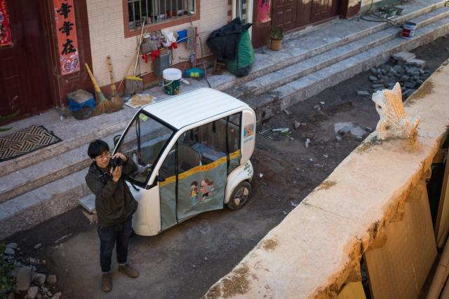 (251117) -- KUNMING, Nov. 17, 2025 (Xinhua) -- Zhang Hang collects images of Wamao with his camera at Haiyan Village in Kunming, southwest China's Yunnan Province, Nov. 12, 2025. Zhang Hang, 32, is an inheritor of the Kunming Wamao-making technique and the founder of the Heart Chamber Wamao Museum.
   Wamao, a cat-shaped pottery artifact originating in Yunnan, combines practical design with folk beliefs. Traditionally mounted on eaves or lintels, it was believed to drive away evil spirits and bring peace to the household. In 2023, Wamao was listed as one of Yunnan's provincial intangible cultural heritage items.
   Zhang first encountered Wamao in 2012, when he was studying folk art design at Yunnan Arts University. "I was drawn to its expressive artistic form," Zhang said. "I wanted to integrate its unconstrained style into modern design."
   Since then, searching for old Wamao has become part of his daily life. He has wandered through old city markets and construction sites, from cities of Dali and Lijiang to the outskirts of Kunming, chasing traces of the clay guardians.
   In 2019, Zhang founded the Wamao museum to promote the craft through exhibitions, hands-on classes, and cultural tours. Visitors can take part in Wamao-making workshops, Wamao placement ceremonies, and field trips to traditional villages.
   In his studio, Zhang mixes clay, shapes the cat's head and body, and then fires it in a kiln after drying. The belly of the cat is left hollow, with its mouth and tail connected, symbolizing the idea of "swallowing evil and releasing blessings."
   Skilled artisans can complete a Wamao in a week, but Zhang said the true challenge lies in merging tradition with innovation.
   "It sometimes takes a month to create one that feels right," he said. "The goal is to help this ancient craft find new meaning in modern society."
   As urbanization changes the landscape of Kunming, many old houses have disappeared. Zhang hopes his work will help preserve the memory of the Wamao and its cultural spirit.
   "As old houses crumble, I hope the chamber of my heart will serve as a new home for Wamao," he said. (Xinhua/Wang Guansen)