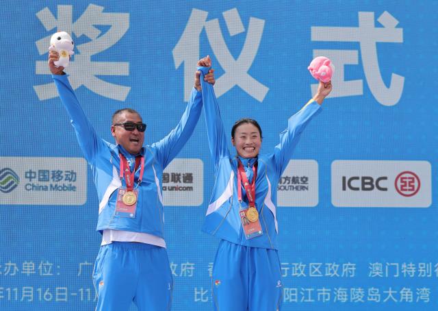 (251117) -- YANGJIANG, Nov. 17, 2025 (Xinhua) -- Gold medalist Ma Bingbing (R) of Liaoning celebrates with her coach during the awarding ceremony for women's single sculls final A of coastal rowing at China's 15th National Games in Yangjiang, south China's Guangdong Province, Nov. 17, 2025. (Xinhua/Li Ran)