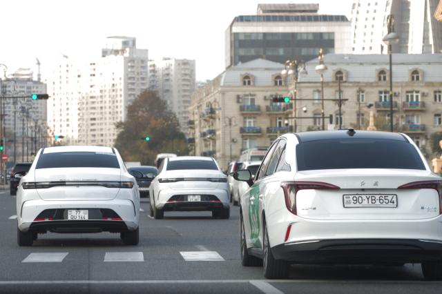 (251117) -- BAKU, Nov. 17, 2025 (Xinhua) -- Cars of BYD brand (L) and Hongqi brand (R) are seen on a street of Baku, Azerbaijan, on Nov. 16, 2025. In the eyes of locals in Baku, Chinese cars are cost-effective, energy-saving, and environmentally friendly, so more and more people are choosing to buy Chinese cars. (Xinhua/Chen Junfeng)