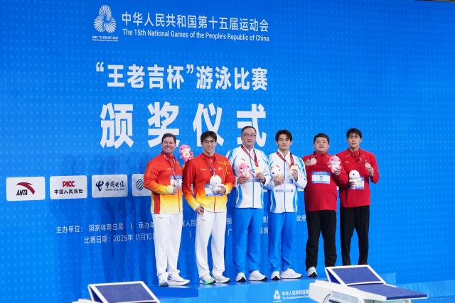 (251117) -- SHENZHEN, Nov. 17, 2025 (Xinhua) -- Gold medalist Xu Jiayu of Zhejiang, silver medalist Wang Zicheng of Hubei and bronze medalist Jiang Chenglin of Shaanxi pose with their coaches during the awarding ceremony for the men's 50m backstroke of swimming at China's 15th National Games in Shenzhen, south China's Guangdong Province, Nov. 17, 2025. (Xinhua/Du Yu)