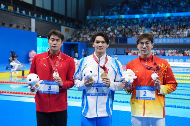 (251117) -- SHENZHEN, Nov. 17, 2025 (Xinhua) -- Gold medalist Xu Jiayu of Zhejiang, silver medalist Wang Zicheng of Hubei and bronze medalist Jiang Chenglin of Shaanxi pose after the awarding ceremony for the men's 50m backstroke of swimming at China's 15th National Games in Shenzhen, south China's Guangdong Province, Nov. 17, 2025. (Xinhua/Du Yu)
