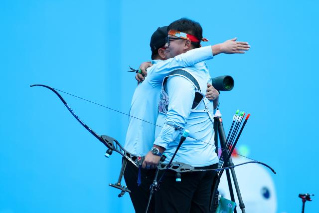 (251117) -- SHENZHEN, Nov. 17, 2025 (Xinhua) -- Li Mengqi (R) of Shandong hugs his coach after winning the men's recurve individual of archery at China's 15th National Games in Shenzhen, south China's Guangdong Province, Nov. 17, 2025. (Xinhua/Mao Siqian)