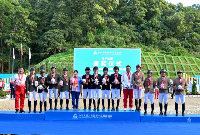 (251117) -- SHENZHEN, Nov. 17, 2025 (Xinhua) -- Gold medalists team Guangxi, sliver medalists team Guangdong and bronze medalists team Inner Mongolia pose with their coaches during the awarding ceremony after the jumping team final of equestrian at China's 15th National Games in Shenzhen, south China's Guangdong Province, Nov. 17, 2025. (Xinhua/Feng Kaihua)