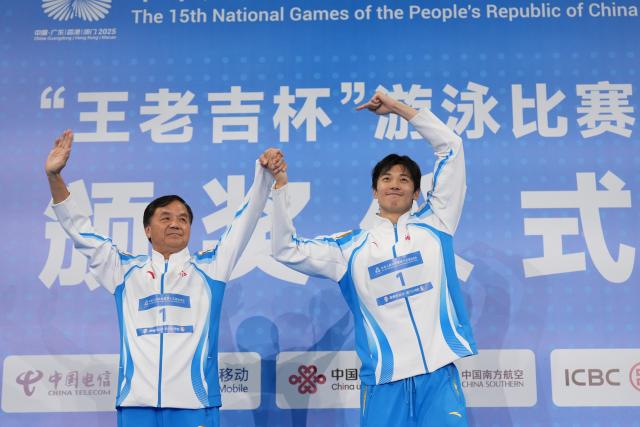(251117) -- SHENZHEN, Nov. 17, 2025 (Xinhua) -- Gold medalist Wang Shun of Zhejiang and his coach are seen during the awarding ceremony for the men's 400m individual medley of swimming at China's 15th National Games in Shenzhen, south China's Guangdong Province, Nov. 17, 2025. (Xinhua/Xue Yuge)