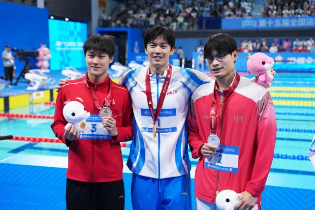 (251117) -- SHENZHEN, Nov. 17, 2025 (Xinhua) -- Gold medalist Wang Shun of Zhejiang, silver medalist Huang Zhiwei of Hunan and bronze medalist He Yubo of Hebei pose after the awarding ceremony for the men's 400m individual medley of swimming at China's 15th National Games in Shenzhen, south China's Guangdong Province, Nov. 17, 2025. (Xinhua/Du Yu)