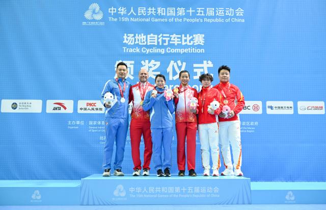 (251117) -- HONG KONG, Nov. 17, 2025 (Xinhua) -- Gold medalist Yuan Liying of Jilin, silver medalist Wang Lijuan of Liaoning and bronze medalist Yang Congge of Sichuan pose with their coaches during the awarding ceremony for women's keirin of cycling track at China's 15th National Games in Hong Kong, south China, Nov. 17, 2025. (Xinhua/Hu Huhu)