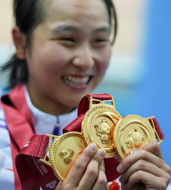 (251117) -- HONG KONG, Nov. 17, 2025 (Xinhua) -- Lee Sze Wing of Hong Kong shows her three gold medals she won at the games after the awarding ceremony for cycling track women's omnium at China's 15th National Games in Hong Kong, south China, Nov. 17, 2025. (Xinhua/Wu Lu)