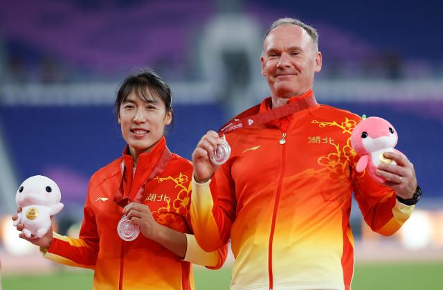 (251117) -- GUANGZHOU, Nov. 17, 2025 (Xinhua) -- Silver medalist Lyu Huihui of Hubei and her coach pose during the awarding ceremony of women's javelin throw of athletics at China's 15th National Games in Guangzhou, south China's Guangdong Province, Nov. 17, 2025. (Xinhua/Huang Wei)