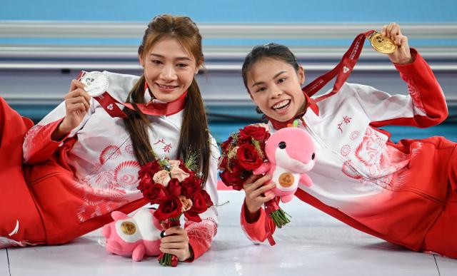 (251117) -- GUANGZHOU, Nov. 17, 2025 (Xinhua) -- Gold medalist Mo Jiadie (R) of Guangdong and silver medalist Kong Yingying of Guangdong pose after the awarding ceremony of the women's 400m hurdles of athletics at China's 15th National Games in Guangzhou, south China's Guangdong Province, Nov. 17, 2025. (Xinhua/Xiao Yijiu)