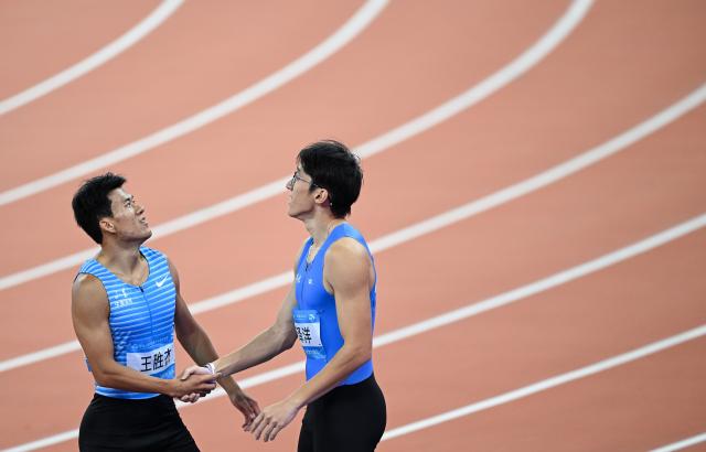 (251117) -- GUANGZHOU, Nov. 17, 2025 (Xinhua) -- Li Zeyang (R) of Hubei shakes hands with Wang Shengjie of Shandong after the men's 100m final of athletics at China's 15th National Games in Guangzhou, south China's Guangdong Province, Nov. 17, 2025. (Xinhua/Deng Hua)
