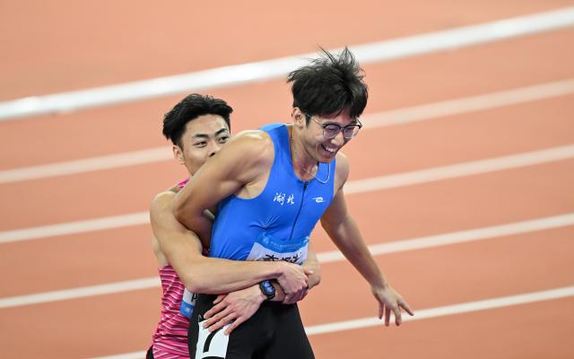 (251117) -- GUANGZHOU, Nov. 17, 2025 (Xinhua) -- Li Zeyang (R) of Hubei celebrates with Chen Guanfeng of Guangdong after the men's 100m final of athletics at China's 15th National Games in Guangzhou, south China's Guangdong Province, Nov. 17, 2025. (Xinhua/Deng Hua)