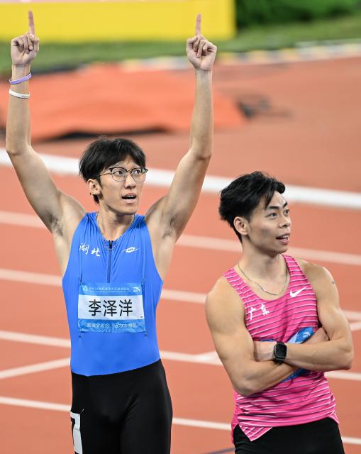(251117) -- GUANGZHOU, Nov. 17, 2025 (Xinhua) -- Li Zeyang (L) of Hubei reacts after the men's 100m final of athletics at China's 15th National Games in Guangzhou, south China's Guangdong Province, Nov. 17, 2025. (Xinhua/Deng Hua)