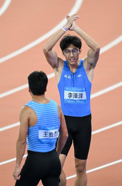 (251117) -- GUANGZHOU, Nov. 17, 2025 (Xinhua) -- Li Zeyang (R) of Hubei reacts after the men's 100m final of athletics at China's 15th National Games in Guangzhou, south China's Guangdong Province, Nov. 17, 2025. (Xinhua/Deng Hua)
