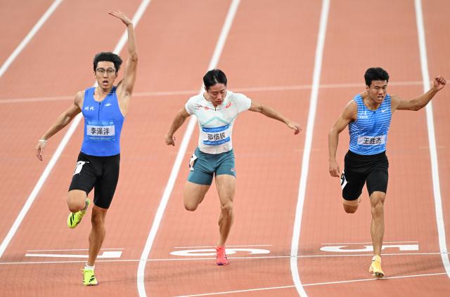 (251117) -- GUANGZHOU, Nov. 17, 2025 (Xinhua) -- Li Zeyang (L) of Hubei, Deng Xinrui (C) of Guangxi and Wang Shengjie of Shandong cross the finish line during the men's 100m final of athletics at China's 15th National Games in Guangzhou, south China's Guangdong Province, Nov. 17, 2025. (Xinhua/Deng Hua)