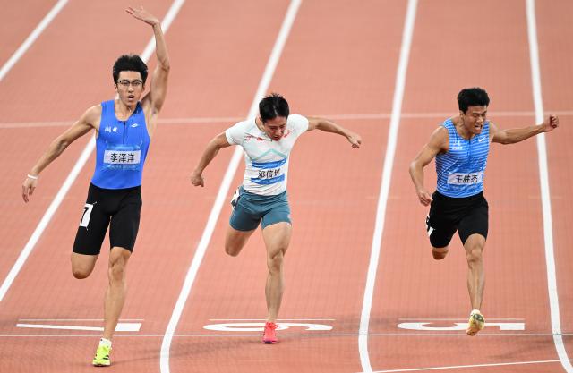 (251117) -- GUANGZHOU, Nov. 17, 2025 (Xinhua) -- Li Zeyang (L) of Hubei, Deng Xinrui (C) of Guangxi and Wang Shengjie of Shandong cross the finish line during the men's 100m final of athletics at China's 15th National Games in Guangzhou, south China's Guangdong Province, Nov. 17, 2025. (Xinhua/Deng Hua)