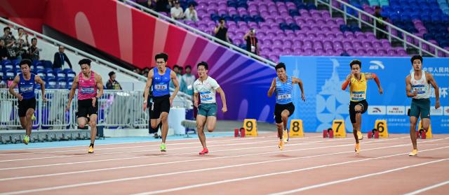 (251117) -- GUANGZHOU, Nov. 17, 2025 (Xinhua) -- Athletes compete during the men's 100m final of athletics at China's 15th National Games in Guangzhou, south China's Guangdong Province, Nov. 17, 2025. (Xinhua/Jiang Han)