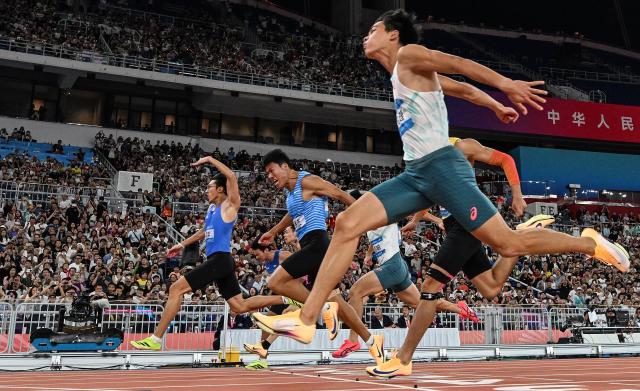 (251117) -- GUANGZHOU, Nov. 17, 2025 (Xinhua) -- Li Zeyang (1st L) of Hubei crosses the finish line during the men's 100m final of athletics at China's 15th National Games in Guangzhou, south China's Guangdong Province, Nov. 17, 2025. (Xinhua/Jiang Han)