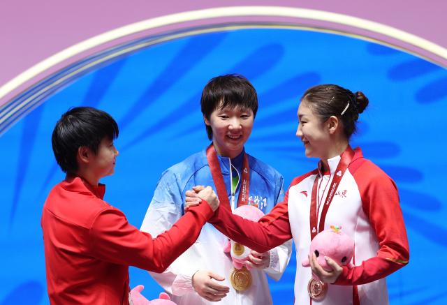 (251118) -- BEIJING, Nov. 18, 2025 (Xinhua) -- Gold medalist Wang Manyu (C) of Heilongjiang, silver medalist Sun Yingsha (L) of Hebei and bronze medalist Chen Meng of Shandong interact during the awarding ceremony for the table tennis women's singles at China's 15th National Games in Macao, south China, Nov. 16, 2025. (Xinhua/Chen Bin)