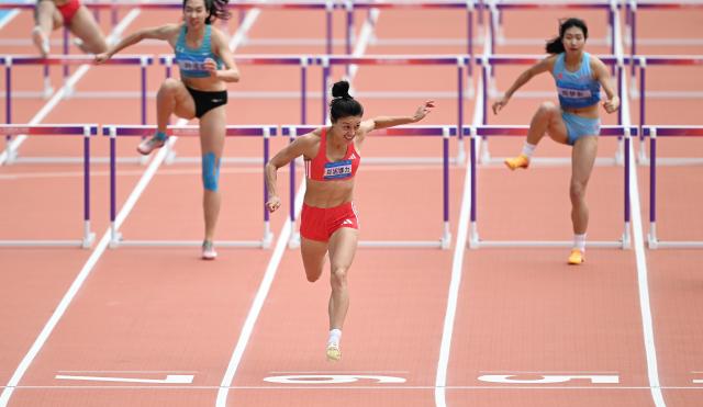 (251118) -- GUANGZHOU, Nov. 18, 2025 (Xinhua) -- Zheng Ninali (front) of Shanxi crosses the finish line during the women's heptathlon 100m hurdles of athletics at China's 15th National Games in Guangzhou, south China's Guangdong Province, Nov. 18, 2025. (Xinhua/Deng Hua)