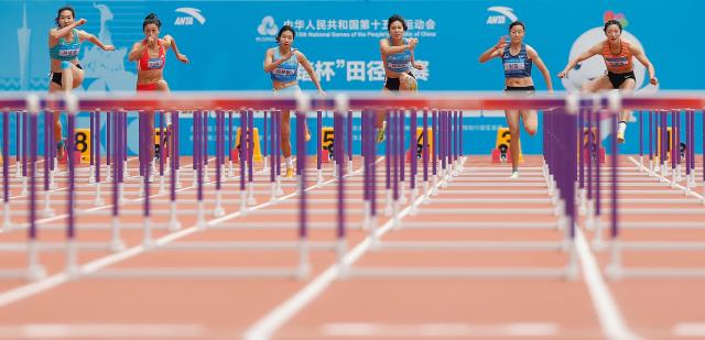 (251118) -- GUANGZHOU, Nov. 18, 2025 (Xinhua) -- Athletes compete during the women's heptathlon 100m hurdles of athletics at China's 15th National Games in Guangzhou, south China's Guangdong Province, Nov. 18, 2025. (Xinhua/Huang Wei)