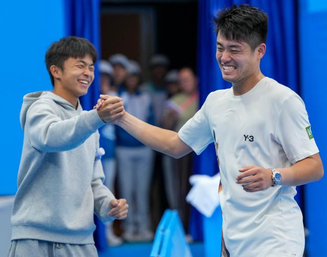 (251118) -- HENGQIN, Nov. 18, 2025 (Xinhua) -- Wu Yibing (R) celebrates after winning the men's singles quarterfinal match of tennis between Wu Yibing of Zhejiang and Sun Fajing of Hebei at China's 15th National Games in Hengqin, south China's Guangdong Province, Nov. 18, 2025. (Xinhua/Yan Linyun)