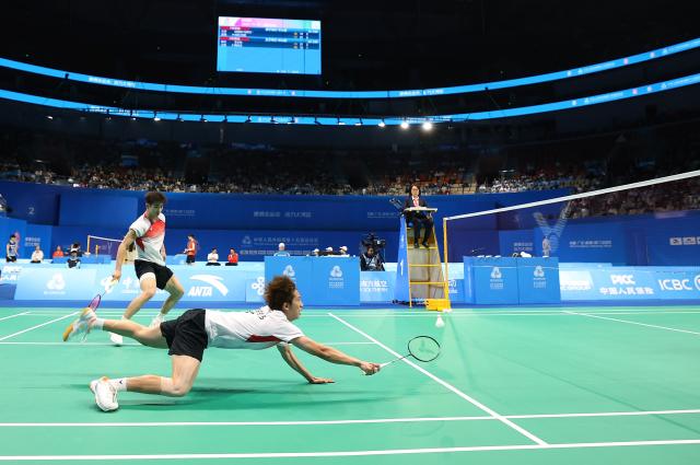 (251118) -- SHENZHEN, Nov. 18, 2025 (Xinhua) -- Liu Yang (front)/Liu Yi compete during the men's doubles semifinal match of badminton between Liu Yuchen/Feng Yanzhe of Beijing and Liu Yang/Liu Yi of Anhui at China's 15th National Games in Shenzhen, south China's Guangdong Province, Nov. 18, 2025. (Xinhua/Ding Ting)