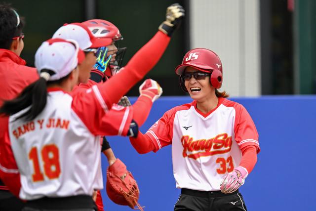 (251118) -- ZHONGSHAN, Nov. 18, 2025 (Xinhua) -- Li Huan (1st R) of Jiangsu celebrates scoring during the final of softball between Jiangsu and Liaoning at China's 15th National Games in Zhongshan, south China's Guangdong Province, Nov. 18, 2025. (Xinhua/Ding Lei)