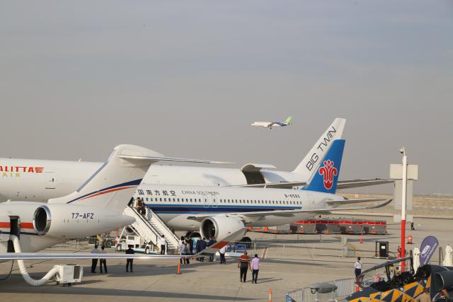 (251118) -- DUBAI, Nov. 18, 2025 (Xinhua) -- This photo taken on Nov. 17, 2025 shows a C919 aircraft developed by Commercial Aircraft Corporation of China (COMAC) flying over a China Southern Airlines C919 aircraft which is on display during the 19th edition of the Dubai Airshow in Dubai, the United Arab Emirates (UAE). The 19th edition of the Dubai Airshow opened Monday at Dubai World Central, featuring the Middle East debut of two of China's homegrown C919 aircraft.
   Organizers said the five-day event, held under the theme "The Future is Here," has drawn more than 1,500 exhibitors, including 440 first-time participants. 
   The Commercial Aircraft Corporation of China (COMAC), maker of the C919, is showcasing one C919 and one C909 aircraft, while China Southern Airlines has brought another C919. The appearance of the C919 marks its first showing in the Middle East, and COMAC performed a flight demonstration of the China-made passenger plane at the venue. (Xinhua/Wen Xinnian)