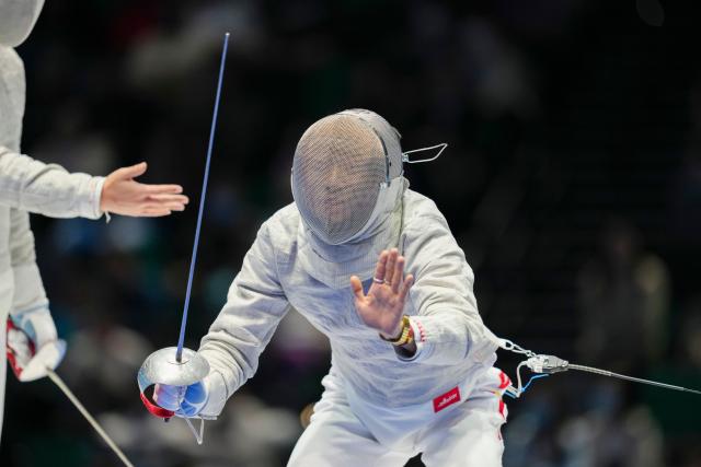 (251118) -- HONG KONG, Nov. 18, 2025 (Xinhua) -- Lu Yang of Jiangsu talks with the referee during the bronze medal match of fencing men's team sabre between Shanghai and Jiangsu at China's 15th National Games in Hong Kong, south China, Nov. 18, 2025. (Xinhua/Wu Lu)