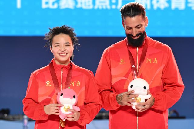 (251118) -- GUANGZHOU, Nov. 18, 2025 (Xinhua) -- Gold medalist Liu Qingyi of Henan poses with her coach during the awarding ceremony for breaking B-Girls at China's 15th National Games in Guangzhou, south China's Guangdong Province, Nov. 18, 2025. (Xinhua/Xiao Yijiu)