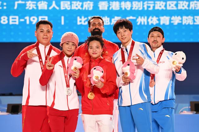 (251118) -- GUANGZHOU, Nov. 18, 2025 (Xinhua) -- Gold medalist Liu Qingyi of Henan, silver medalist Guo Pu of Shandong and bronze medalist Zeng Yingying of Zhejiang pose with their coaches during the awarding ceremony for breaking B-Girls at China's 15th National Games in Guangzhou, south China's Guangdong Province, Nov. 18, 2025. (Xinhua/Xiao Yijiu)