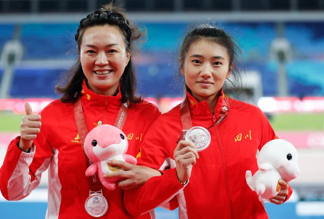 (251118) -- GUANGZHOU, Nov. 18, 2025 (Xinhua) -- Silver medalist Du Rui of Sichuan poses with her coach during the awarding ceremony for the women's pole vault of athletics at China's 15th National Games in Guangzhou, south China's Guangdong Province, Nov. 18, 2025. (Xinhua/Huang Wei)