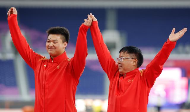 (251118) -- GUANGZHOU, Nov. 18, 2025 (Xinhua) -- Silver medalist Li Zixu of Jiangsu and his coach wave during the awarding ceremony for the men's hammer throw of athletics in Guangzhou, south China's Guangdong Province, Nov. 18, 2025. (Xinhua/Huang Wei)