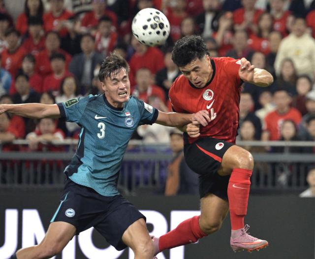 (251118) -- HONG KONG, Nov. 18, 2025 (Xinhua) -- Leon Jones (R) of China's Hong Kong vies with Ryhan Stewart of Singapore during the AFC Asian Cup 2027 Qualifiers 3rd round group C football match between China's Hong Kong and Singapore in Hong Kong, south China, Nov. 18, 2025. (Xinhua/Lo Ping Fai)
