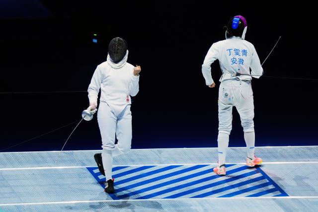 (251118) -- HONG KONG, Nov. 18, 2025 (Xinhua) -- Chen Jinbao (L) of Fujian celebrates scoring against Ding Wenqing of Anhui during the women's team epee final of fencing between Fujian and Anhui at China's 15th National Games in Hong Kong, south China, Nov. 18, 2025. (Xinhua/Zhu Wei)