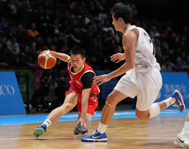 (251118) -- MACAO, Nov. 18, 2025 (Xinhua) -- He Wenwei (L) of Guangdong vies with Yao Keyu of Shandong during the U18 men's final match of basketball between Shandong and Guangdong at China's 15th National Games in Macao, south China, Nov. 18, 2025. (Xinhua/Zhou Mi)