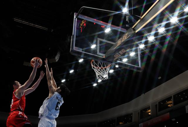 (251118) -- MACAO, Nov. 18, 2025 (Xinhua) -- Mi Shaojie (L) of Guangdong goes for a layup during the U18 men's final match of basketball between Shandong and Guangdong at China's 15th National Games in Macao, south China, Nov. 18, 2025. (Xinhua/Sun Fanyue)