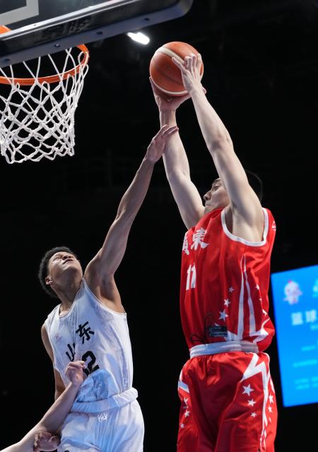 (251118) -- MACAO, Nov. 18, 2025 (Xinhua) -- Feng Xirui (R) of Guangdong fights for the rebound against Peng Hongsen of Shandong during the U18 men's final match of basketball between Shandong and Guangdong at China's 15th National Games in Macao, south China, Nov. 18, 2025. (Xinhua/Zhou Mi)